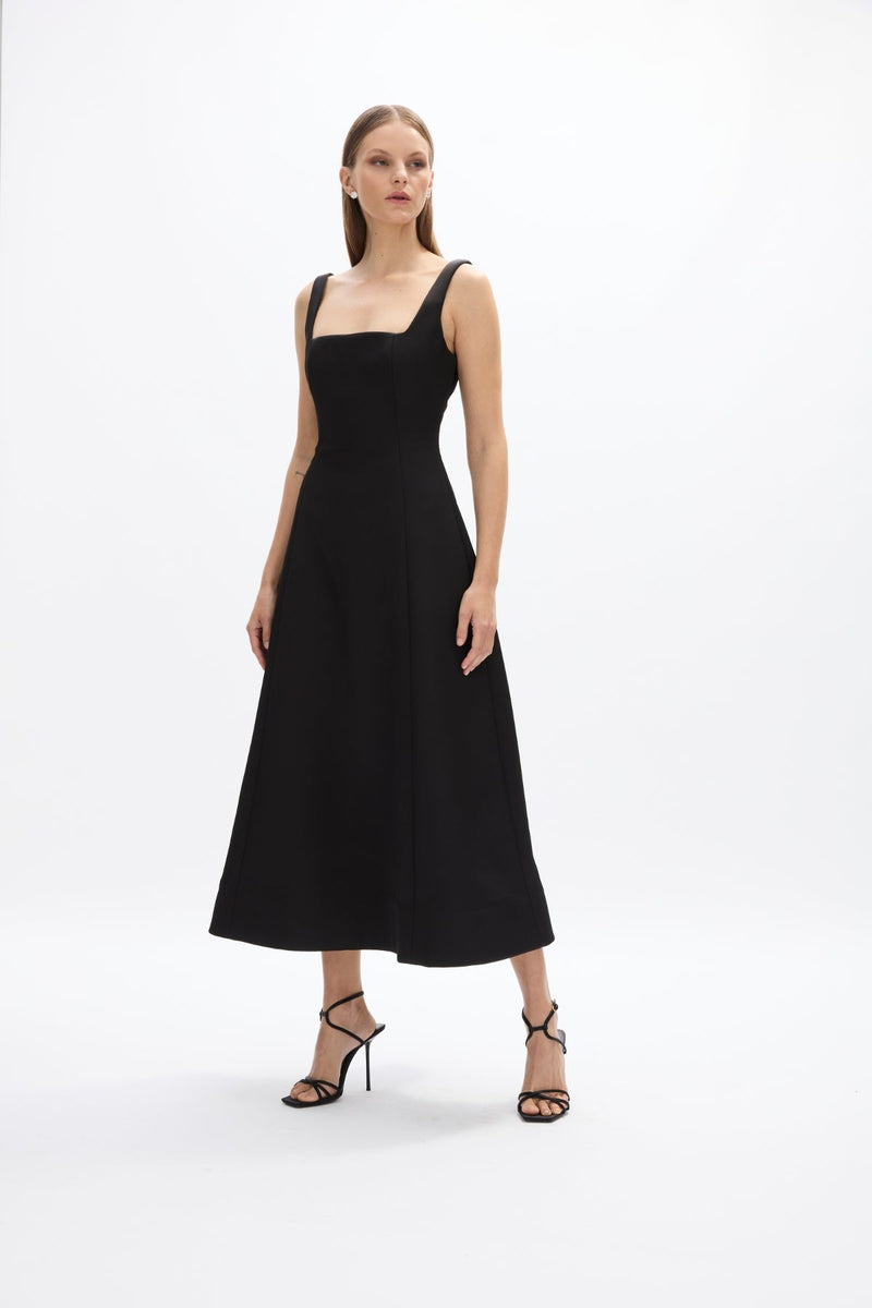 Sera Dress: elegant black cocktail dress featuring square neckline and flowing skirt, perfect for evening events.