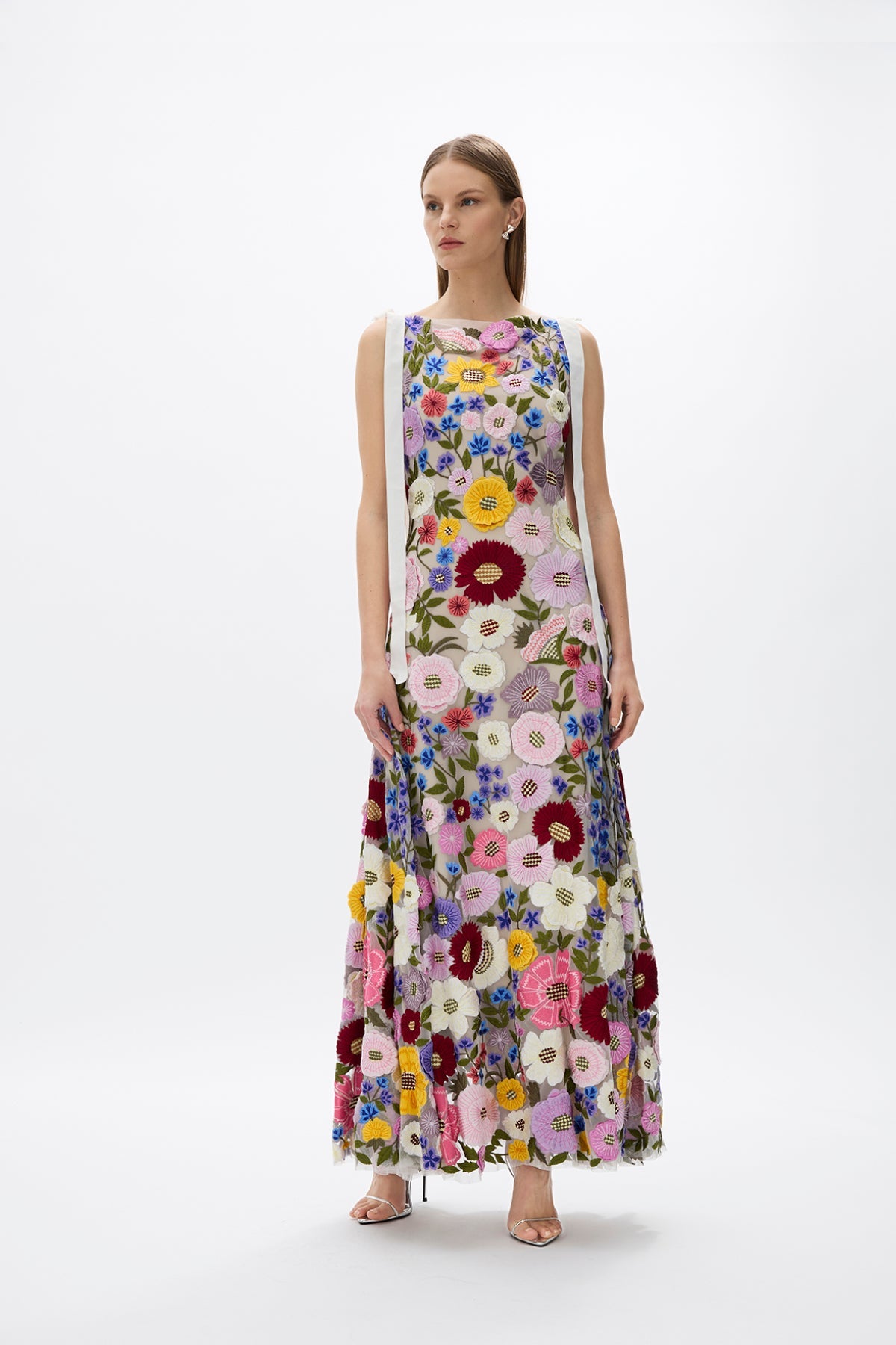 Nya Gown: beautiful floor-grazing floral gown with hand-embroidered details, ribbon ties on the shoulders, and a flowing skirt, ideal for day events. 